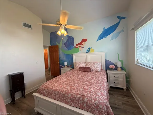 Bedroom featuring dark wood-style floors, vaulted ceiling, and ceiling fan