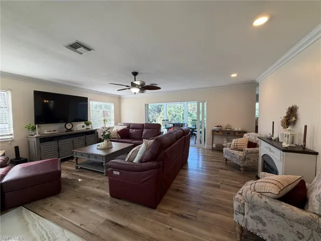 Living room featuring ornamental molding, hardwood / wood-style floors, a ceiling fan, and recessed lighting