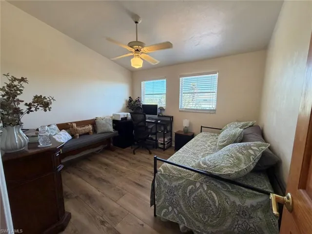 Bedroom featuring hardwood / wood-style flooring, an office area, and ceiling fan