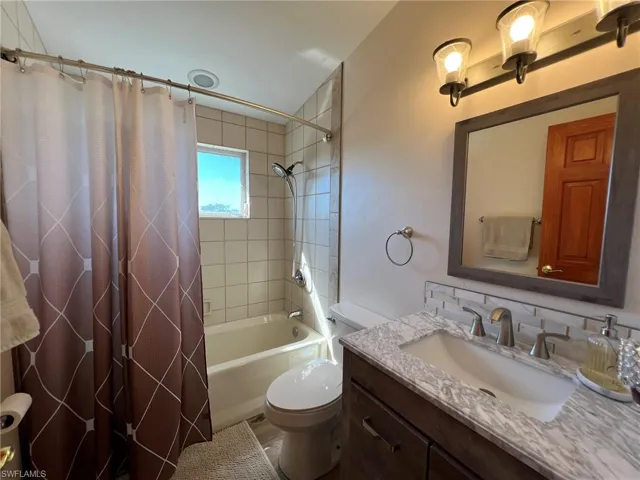Bathroom featuring shower / tub combo, vanity, and toilet