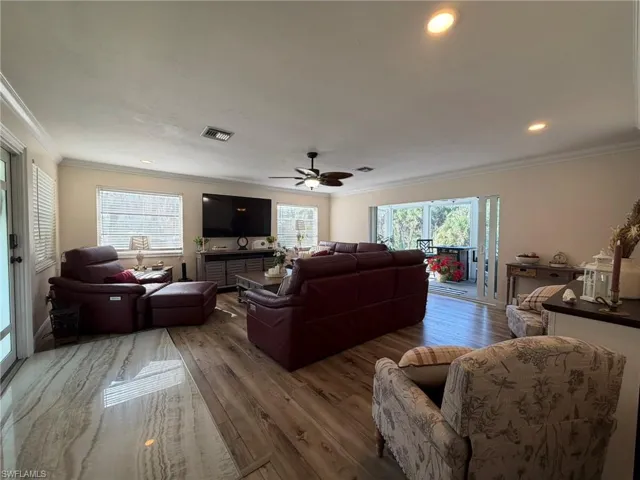 Living room featuring crown molding, hardwood / wood-style floors, ceiling fan, and recessed lighting