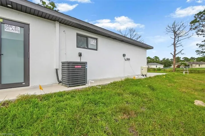 View of property exterior with stucco siding and a yard