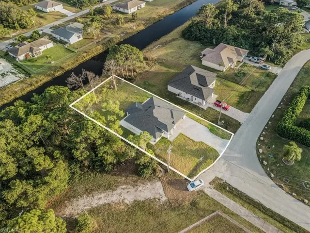 Aerial perspective of suburban area featuring a nearby body of water and property parcel outlined
