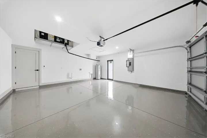 Garage featuring electric water heater and recessed lighting