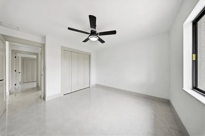 Unfurnished bedroom featuring a ceiling fan and a closet