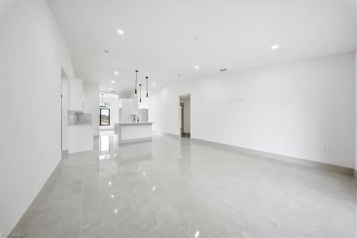 Unfurnished living room with recessed lighting and lofted ceiling