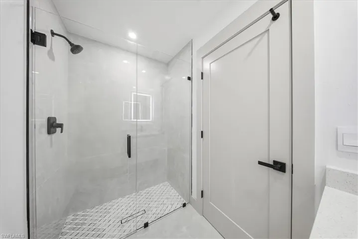 Bathroom with a stall shower and recessed lighting