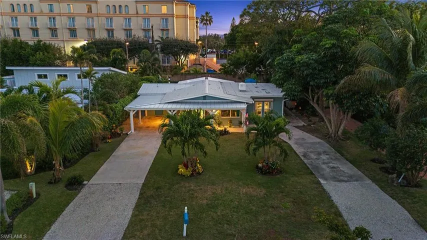 View of front of property with a carport and a yard