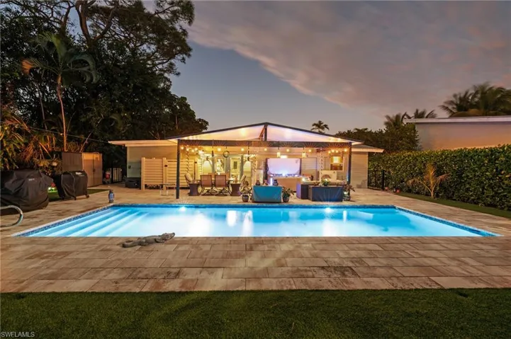 Pool at dusk featuring a patio and an outdoor structure