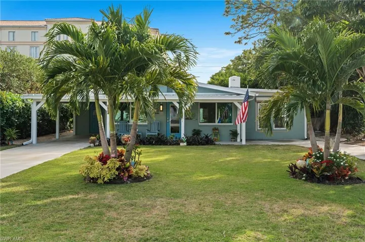 View of front of property featuring a carport and a front lawn