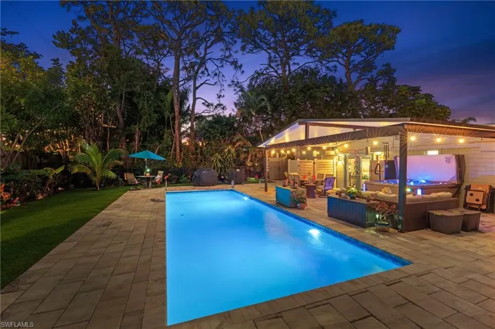 Pool at dusk with a grill, an outdoor structure, outdoor lounge area, and a patio area