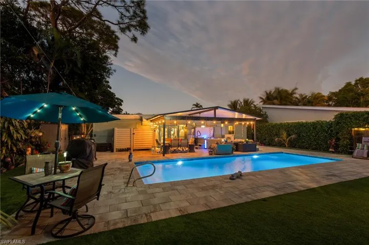 Pool at dusk featuring grilling area, a patio area, and outdoor lounge area