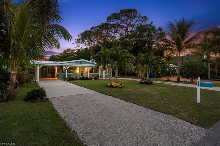 Single story home with a carport and a yard