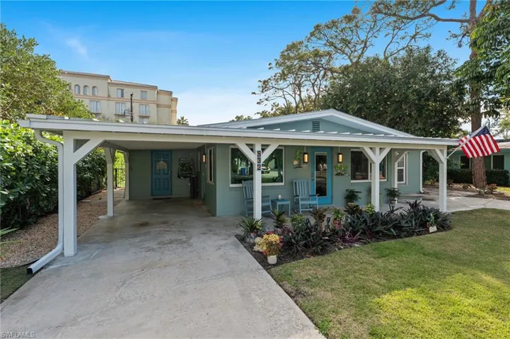 View of front of house with a carport, covered porch, and a front lawn