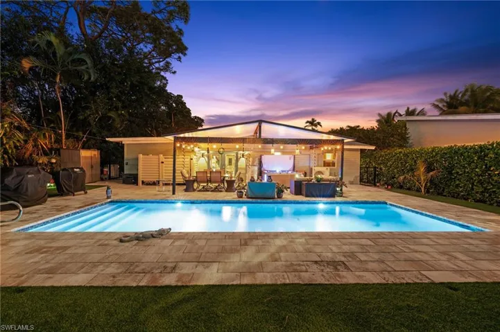 Pool at dusk featuring a storage shed, a patio area, and grilling area