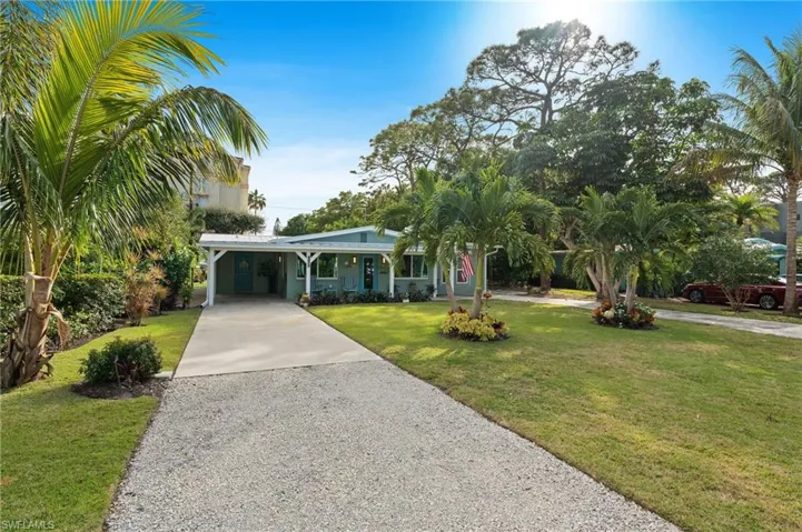 View of front of property featuring a carport and a front yard