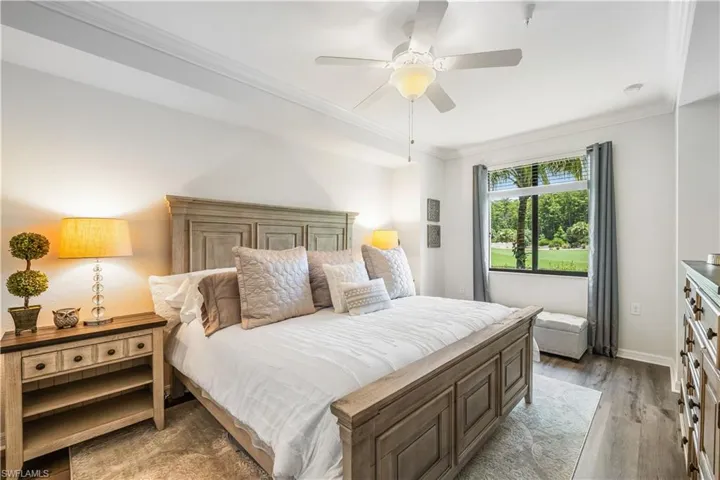Bedroom with light wood-type flooring, ceiling fan, and ornamental molding