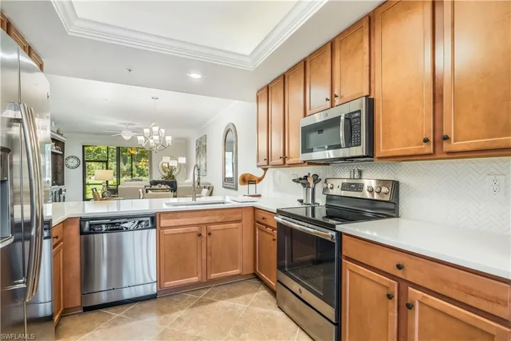 Kitchen featuring stainless steel appliances, ornamental molding, sink, and kitchen peninsula