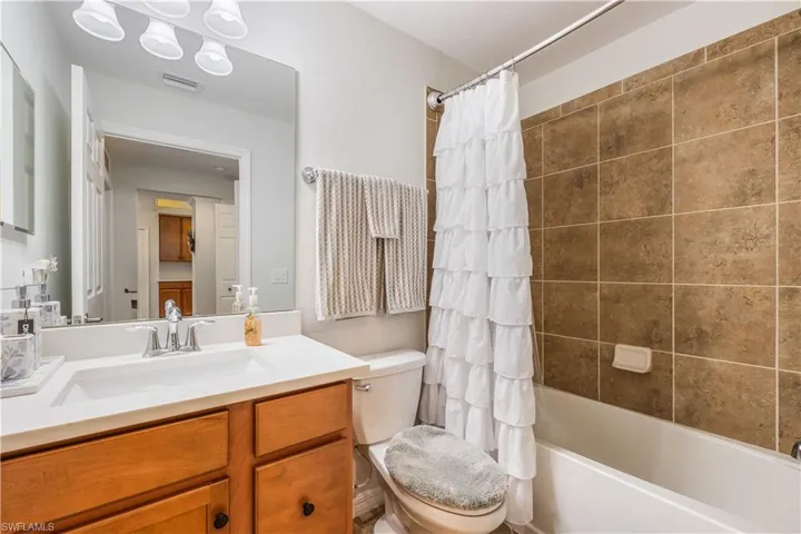 Full bathroom featuring vanity, shower / bath combo, and toilet