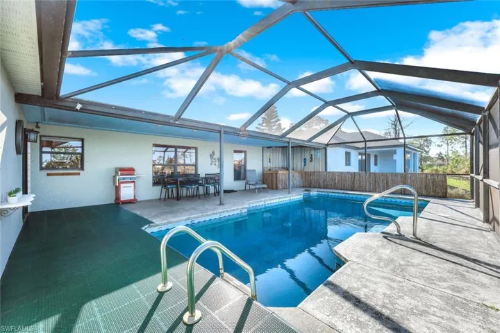 Pool with glass enclosure and a patio