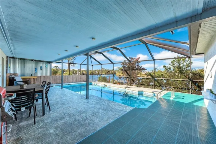 Pool featuring a lanai, a water view, and a patio