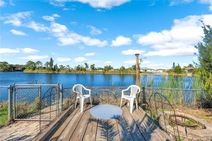 Wooden deck featuring a water view and fence