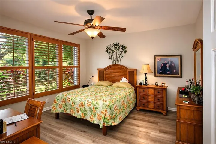 Bedroom featuring wood finished floors, multiple windows, and a ceiling fan