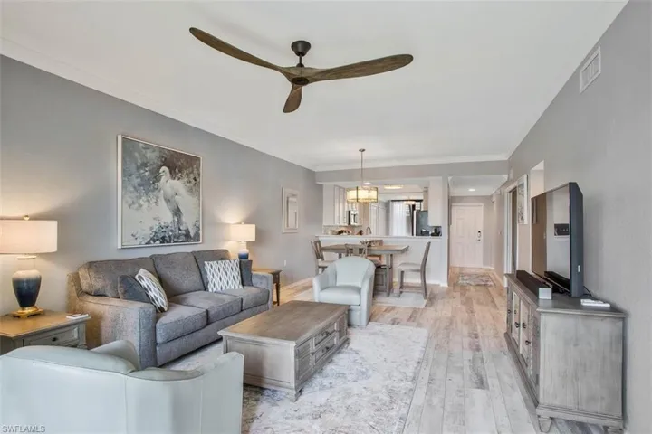 Kitchen featuring light hardwood / wood-style flooring, backsplash, ornamental molding, appliances with stainless steel finishes, and sink