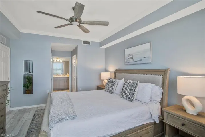 Bedroom with ceiling fan, hardwood / wood-style floors, ensuite bath, and ornamental molding