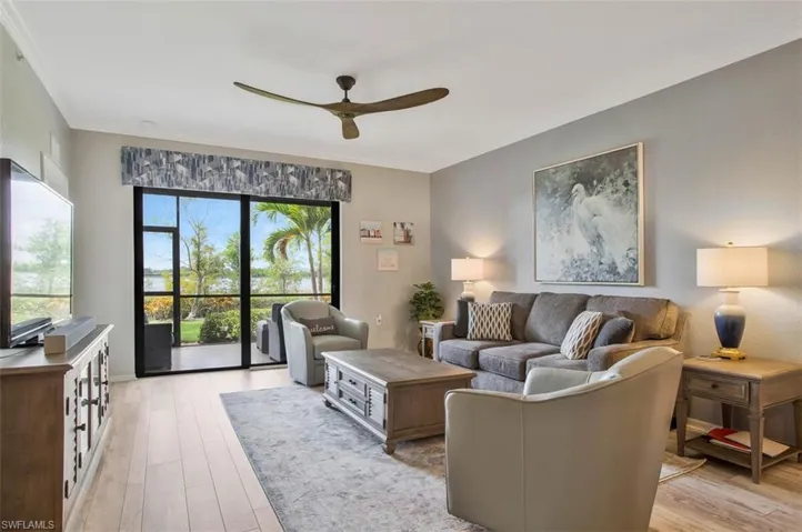 Living room with LAKE VIEWS, sunny rear exposure,  ornamental molding, ceiling fan, and light hardwood / wood-style flooring