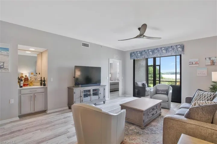 Living room open to LAKE VIEWS and wealth of natural light from sunny rear exposure.
