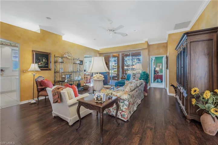 Living room featuring crown molding, ceiling fan, dark hardwood / wood-style floors, and french doors