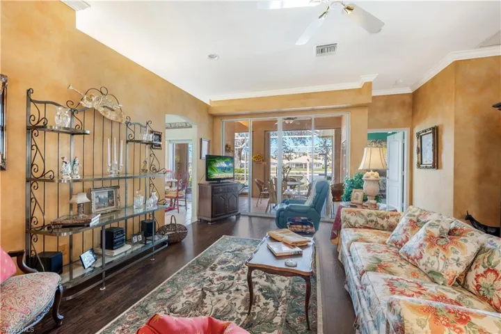 Living room featuring ceiling fan, crown molding, and dark hardwood / wood-style flooring
