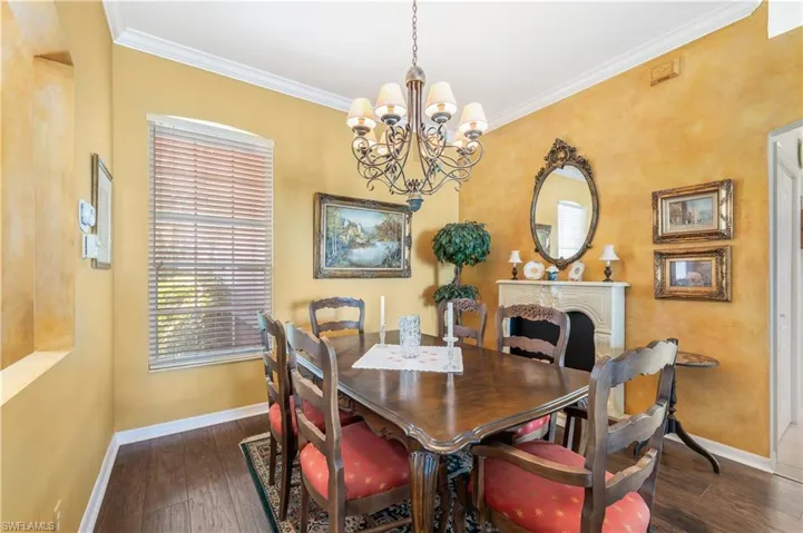 Dining area featuring crown molding, an inviting chandelier, and dark wood-type flooring
