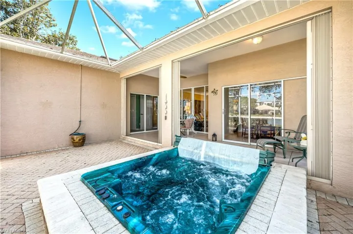 View of pool with an outdoor hot tub and a patio area