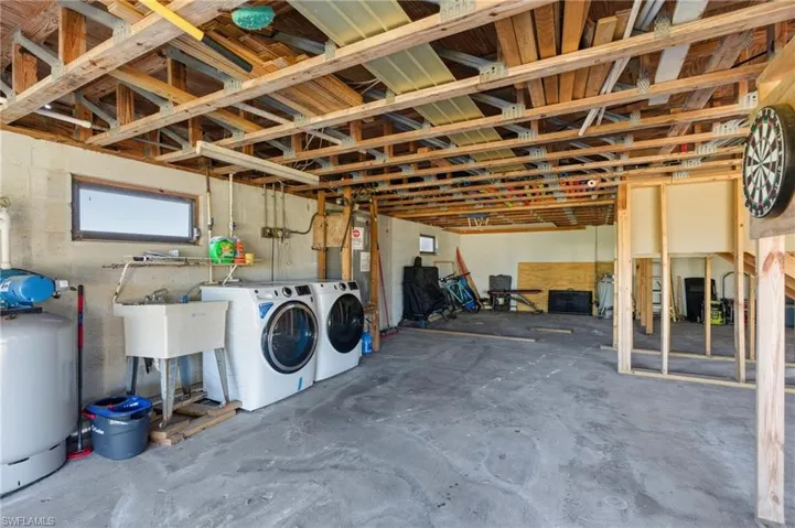 Basement featuring a water pressure tank and separate washer and dryer