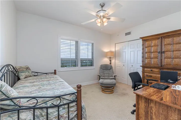 Bedroom with carpet flooring, a desk, a closet, baseboards, and ceiling fan