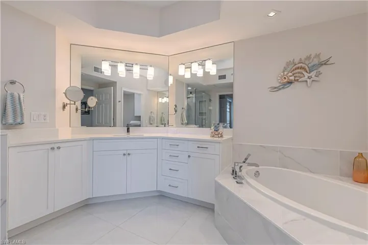 Full bathroom with a garden tub, vanity, and tile patterned flooring