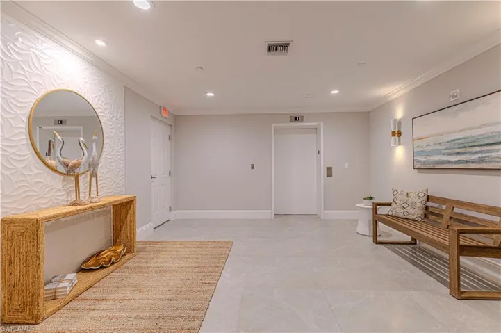 Corridor featuring elevator, recessed lighting, ornamental molding, and baseboards