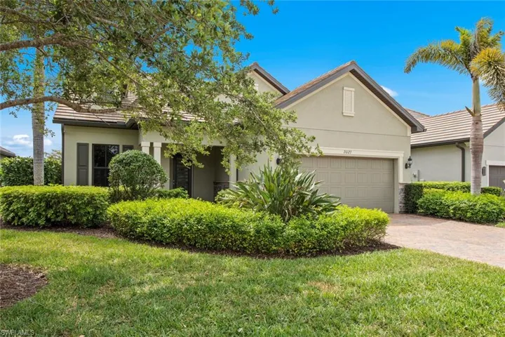 View of front facade with stucco siding, a garage, a front yard, and decorative driveway