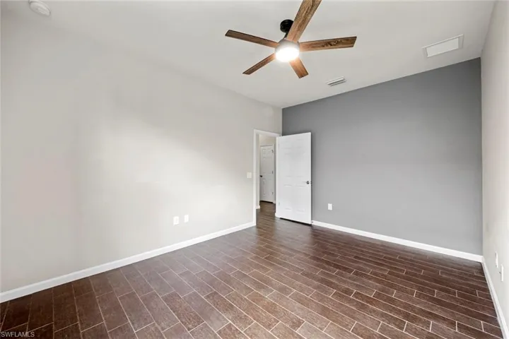 Empty room featuring dark wood finished floors and baseboards