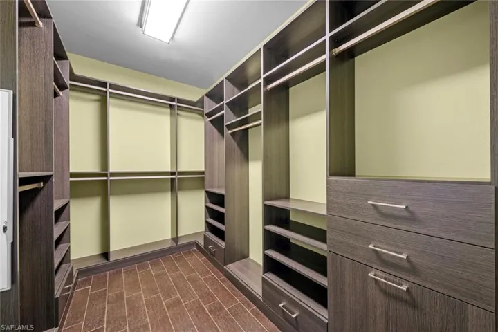 Walk in closet with wood finish floors