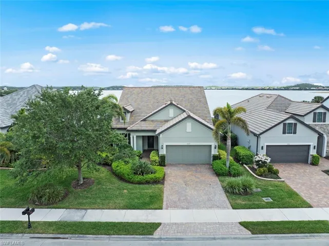 View of front of home with a garage, driveway, stucco siding, and a front lawn