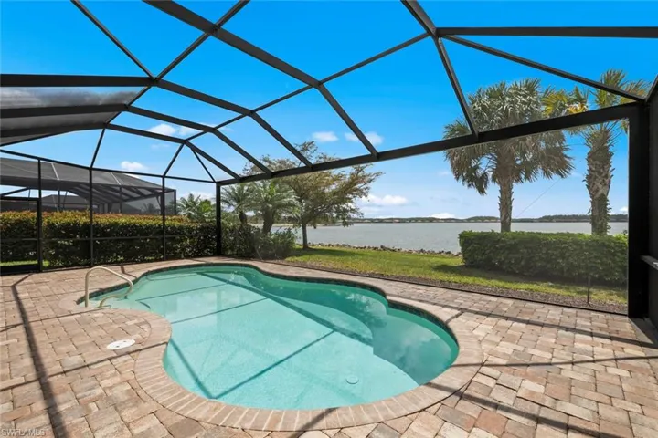 Outdoor pool with a water view, a lanai, and a patio area