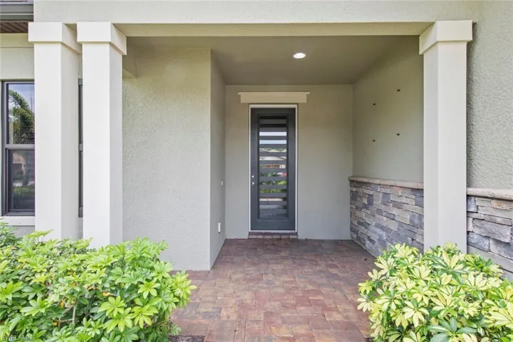 View of exterior entry with stone siding and stucco siding