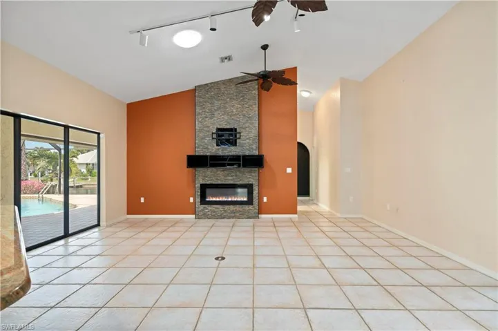 Decorative fireplace, vaulted ceiling, ceiling fans, view of pool