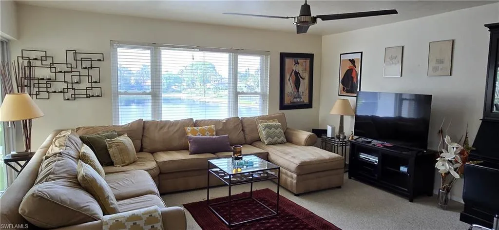 Carpeted living room featuring ceiling fan