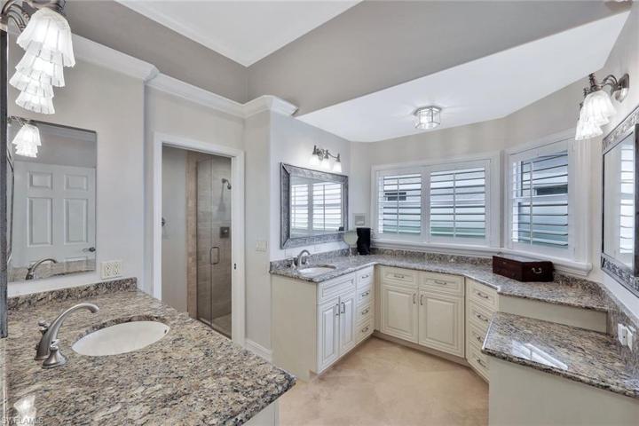 En suite primary bath with separate vanity/sink areas. Walk in shower and toilet are privately tucked away behind the door.