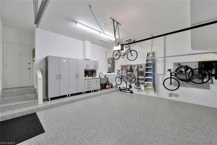 Spacious 2 car garage with storage cabinets and new epoxy flooring.