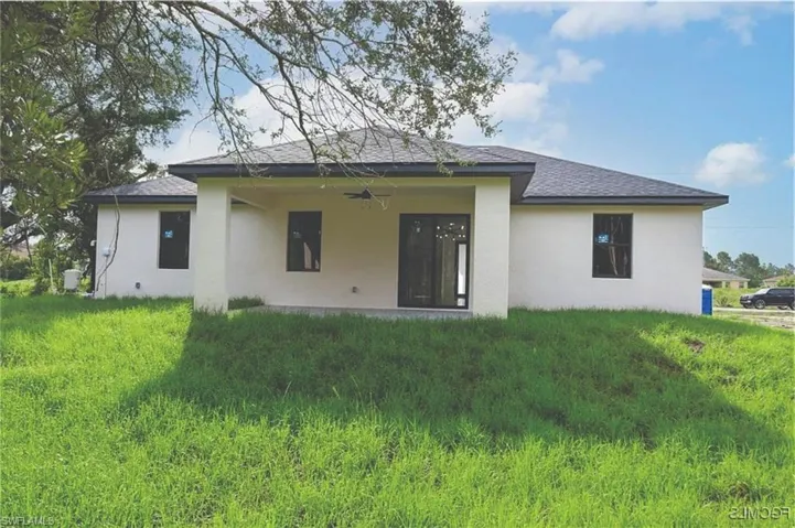Back of property featuring a ceiling fan, a patio, stucco siding, and a shingled roof